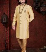 Golden-beige sherwani with stand collar, pearl necklace, and embellished pocket square.
