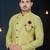 Light-yellow patterned sherwani with ornate buttons, burgundy pocket, and gold trousers.