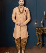 Peach patterned sherwani with pearl accessories, burgundy pocket, and gold trousers.