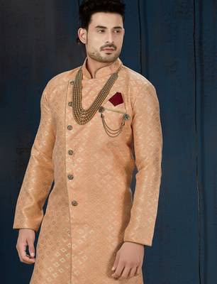 Peach patterned sherwani with pearl accessories, burgundy pocket, and gold trousers. 2