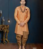 Peach jacquard sherwani with pearl accessories, burgundy pocket, and gold trousers.