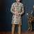 Cream floral sherwani with blue motifs, gold buttons, and gold trousers.