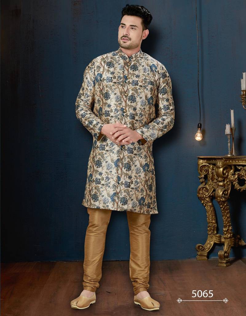 Cream floral sherwani with blue motifs, gold buttons, and gold trousers.