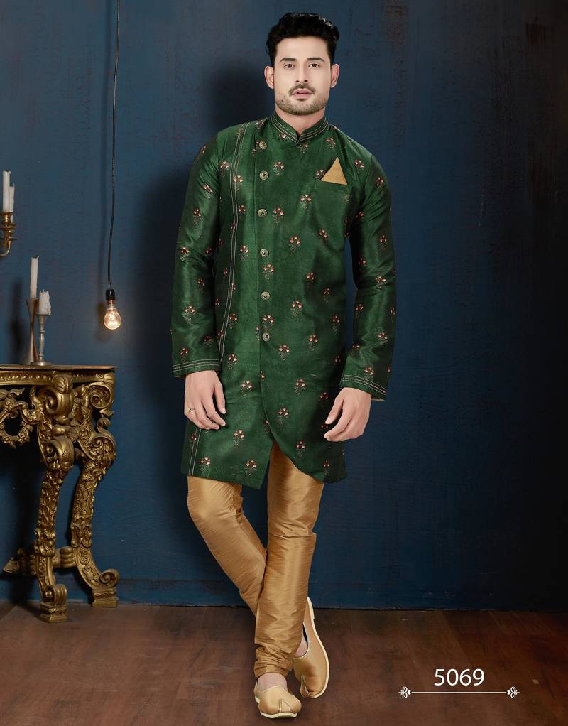 Emerald-green sherwani with floral motifs, gold pocket square, and gold trousers.