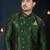 Emerald-green sherwani with floral motifs, gold pocket square, and gold trousers.