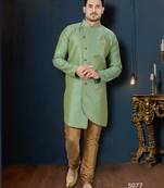 Mint-green patterned sherwani with asymmetrical front, gold pocket square, and gold trousers.