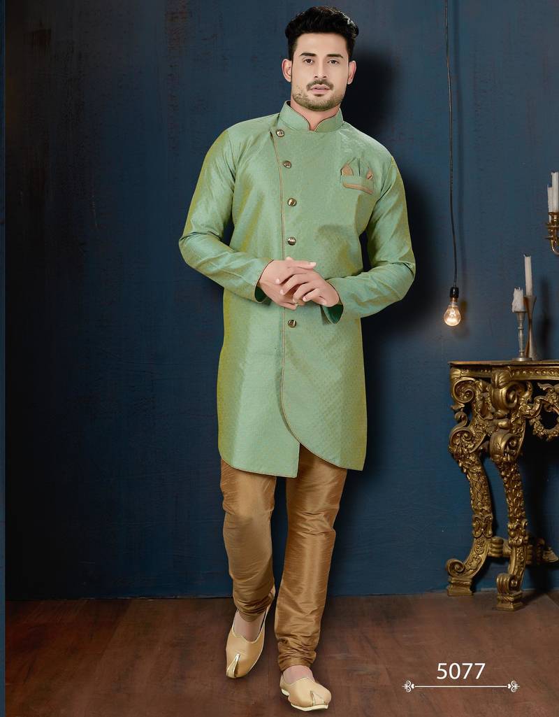 Mint-green patterned sherwani with asymmetrical front, gold pocket square, and gold trousers.