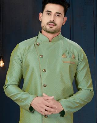 Mint-green patterned sherwani with asymmetrical front, gold pocket square, and gold trousers. 2