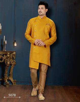 Mustard-yellow sherwani with jacquard texture, asymmetrical front, and matching pocket square. 1