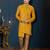 Mustard-yellow sherwani with jacquard texture, asymmetrical front, and matching pocket square.