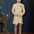 Cream sherwani with brown motifs, ornate buttons, chain pocket detail, and brown trousers.