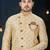 Cream sherwani with brown motifs, ornate buttons, chain pocket detail, and brown trousers.