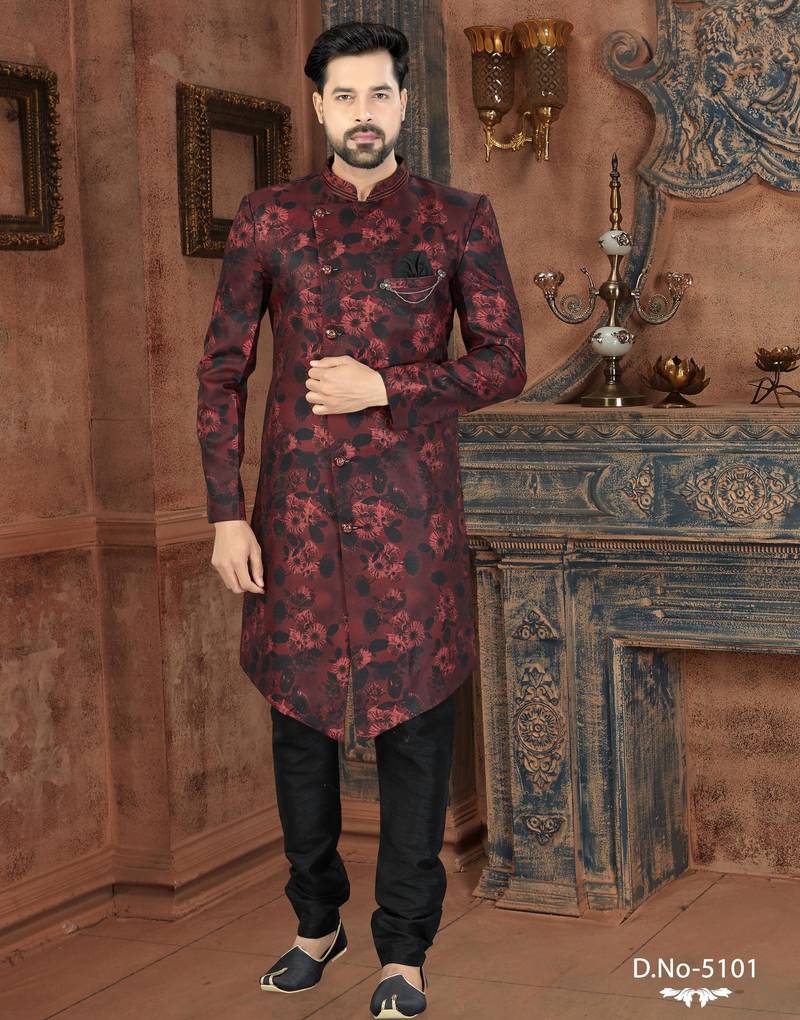 Burgundy floral sherwani with black patterns, chain pocket detail, and black trousers.
