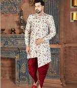 Off white floral sherwani with coral pocket accent and red trousers.