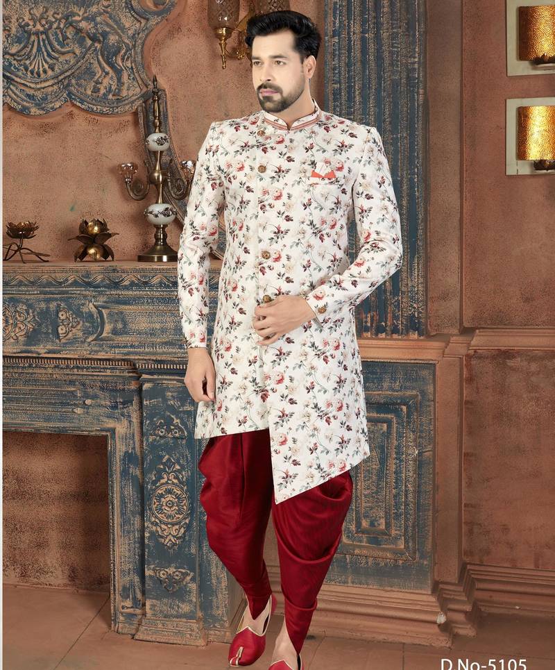 Off white floral sherwani with coral pocket accent and red trousers.