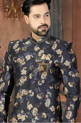 Navy floral sherwani with embellished pocket and ivory dhoti-style trousers.