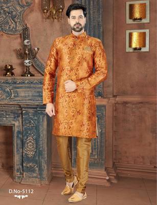 Rust-orange floral sherwani with ornate buttons, matching pocket square, and gold trousers. 1