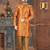 Rust-orange floral sherwani with ornate buttons, matching pocket square, and gold trousers.