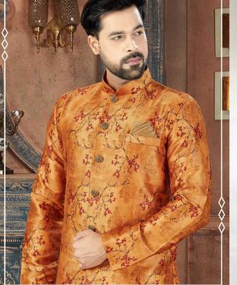 Rust-orange floral sherwani with ornate buttons, matching pocket square, and gold trousers. 2
