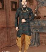 Dark blue sherwani with teal-rust botanical patterns, pearl accessories, and gold dhoti-style trousers.