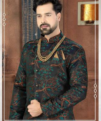 Dark blue sherwani with teal-rust botanical patterns, pearl accessories, and gold dhoti-style trousers. 2