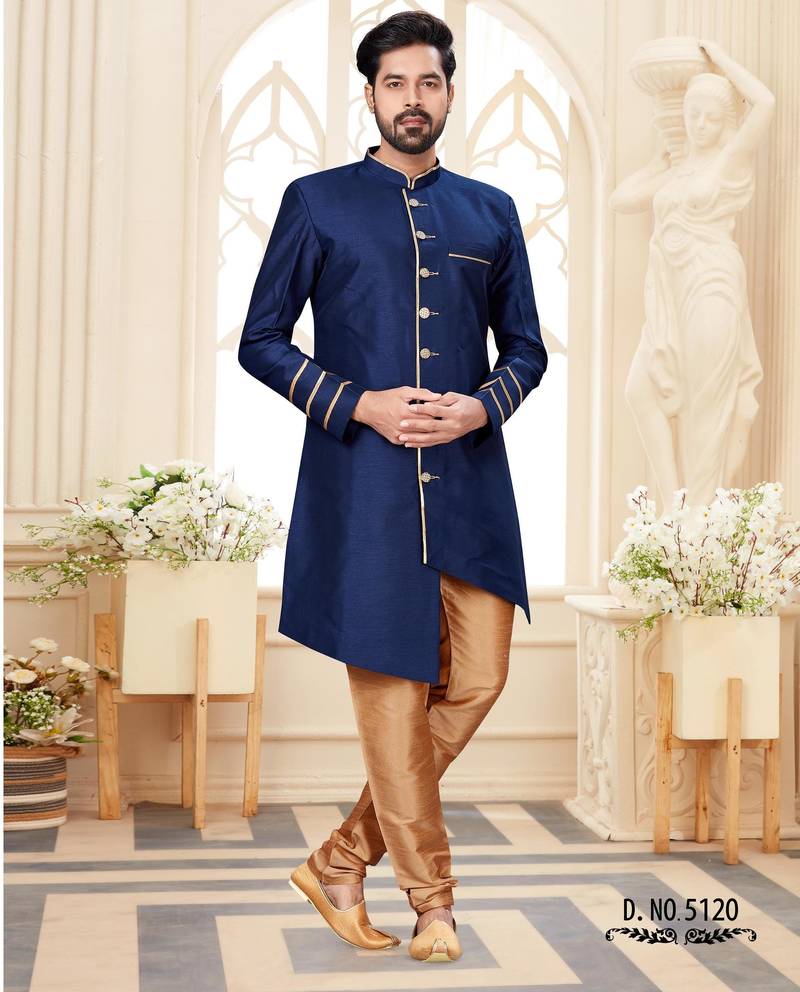 Beige sherwani with striped cuffs, chain pocket detail, and brown trousers.