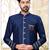 Beige sherwani with striped cuffs, chain pocket detail, and brown trousers.