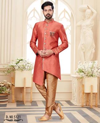 Coral-peach sherwani with gold piping, chain pocket, and gold trousers. 1