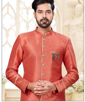 Coral-peach sherwani with gold piping, chain pocket, and gold trousers. 2