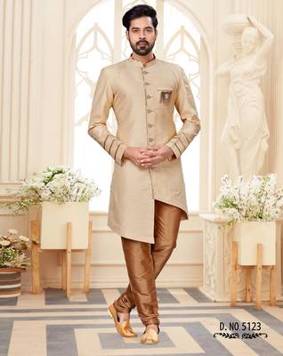 Beige sherwani with striped cuffs, chain pocket, and brown trousers. 1