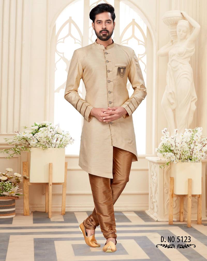 Beige sherwani with striped cuffs, chain pocket, and brown trousers.