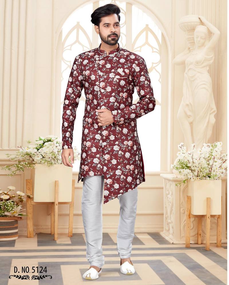 Maroon floral sherwani with asymmetrical front, white pocket square, and white trousers.