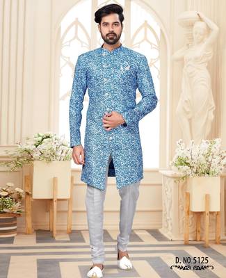 Blue-and-white patterned sherwani with asymmetrical front, matching pocket square, and white trousers. 1