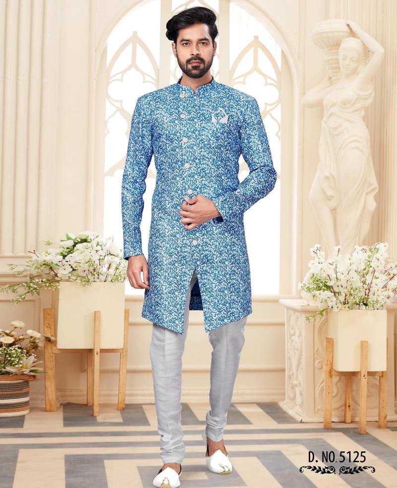 Blue-and-white patterned sherwani with asymmetrical front, matching pocket square, and white trousers.