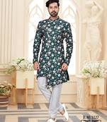 Deep-teal floral sherwani with asymmetrical front, ivory pocket square, and white trousers.