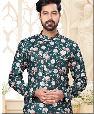 Deep-teal floral sherwani with asymmetrical front, ivory pocket square, and white trousers. 2