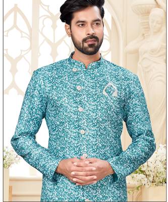 Teal-and-white patterned sherwani with asymmetrical front, matching pocket square, and white trousers. 2