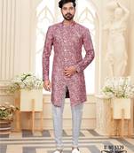 Dark-maroon-and-white patterned sherwani with asymmetrical front, with white trousers.
