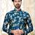 Teal floral sherwani with matching pocket square and cream dhoti-style trousers.
