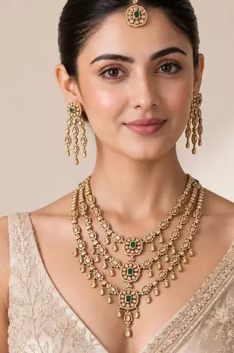 Gold plated emerald green kundan layered necklace set with maang tikka
