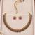 Gold-tone necklace set with alternating pink and green teardrop stones