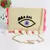 Creme Evil Eye Sling Bag