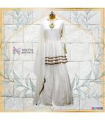 This off white dress has a peplum top with antique handwork done in three layers with a banarasi skirt