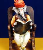 Ganpatiji on a Wooden Chair Reading News Paper