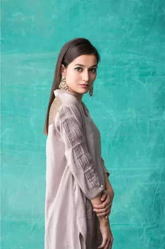 Show Shaa High low fabric manipulated kurta waccompanied byembroided  golden birds on pants.