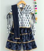 white printed kurti with a triple layered bandhini sharara and a blue dupatta