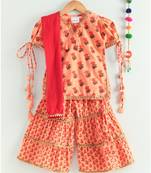 floral peach kurti with a triple layered sharara and a red dupatta