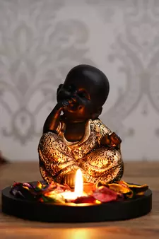 eCraftIndia Decorative Smiling Golden Monk Buddha with Wooden Base, Fragranced Petals and Tealight