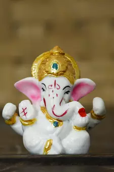 white lord ganesha idol with golden mukut